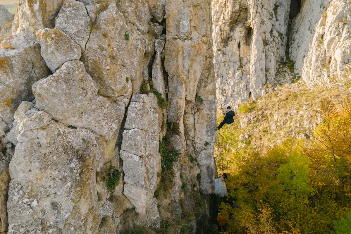 Cuplu pe un vârf stâncos din Apuseni, cu peisaj larg în spate — locație de munte lângă Cluj-Napoca pentru o cerere în căsătorie