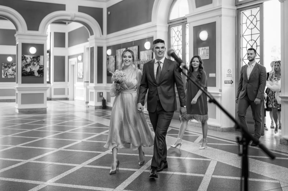 Mirii traversând holul cu coloane al clădirii Casino din Parcul Central Cluj-Napoca, după cununia civilă (alb-negru)