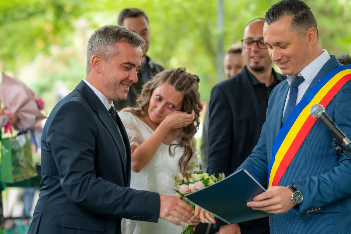 Ofițerul de stare civilă înmânează certificatul mirilor la o cununie civilă în Cluj-Napoca, moment plin de emoție