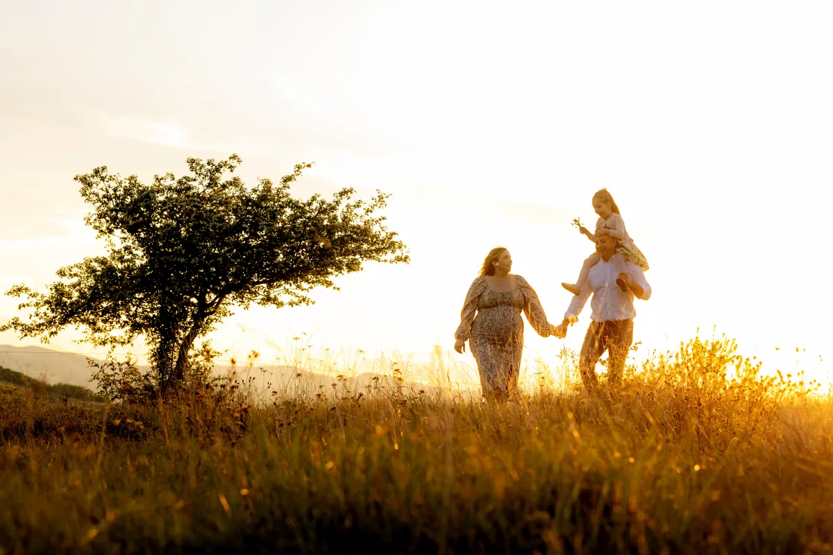 Family walking on a hill at summer sunset — family photo session near Cluj-Napoca