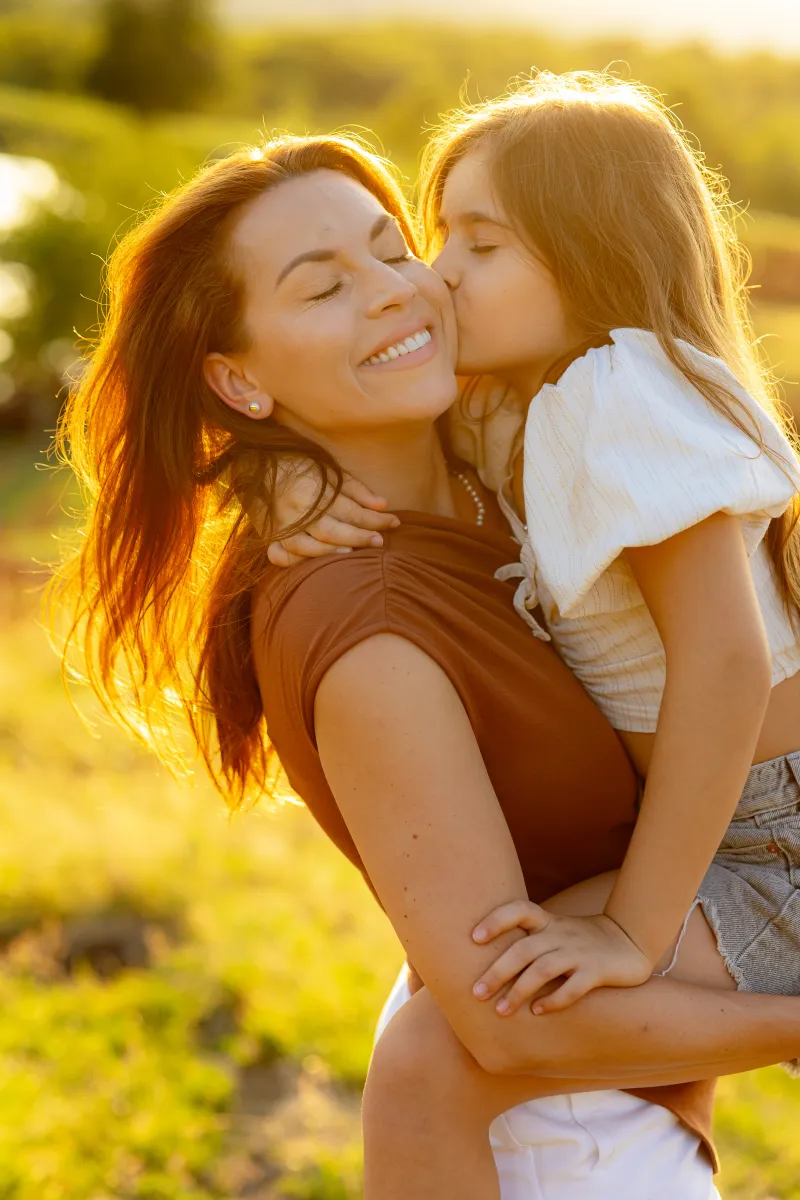 Mother and daughter in warm complementary tones, terracotta and cream, at a sunset family session in Cluj-Napoca
