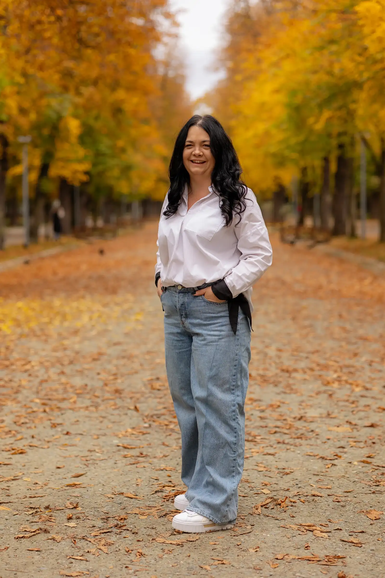 Portret cu mama mergând spre obiectiv, pe covorul de frunze