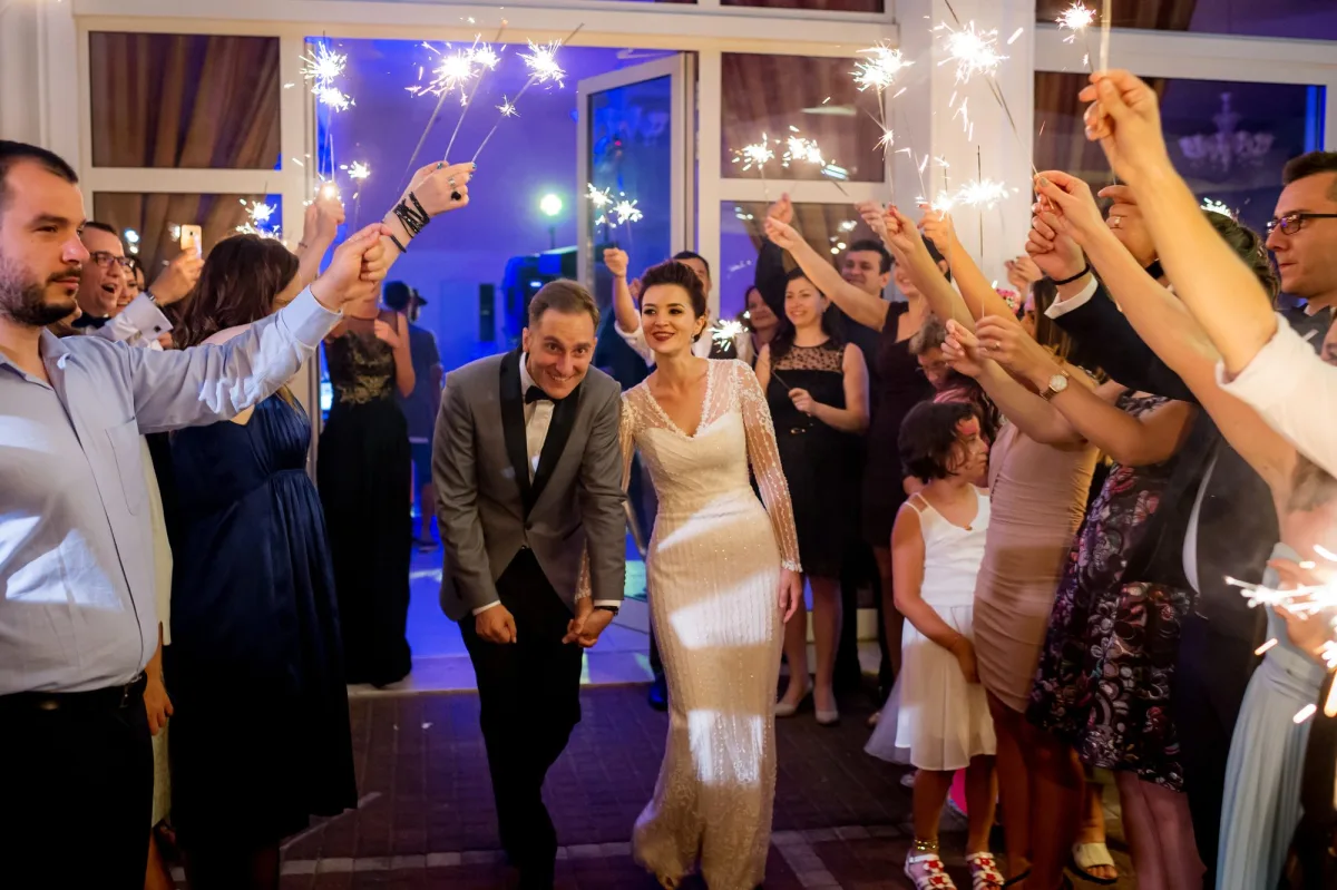 Mirii trecând prin culoarul de scântei reci ținute de invitați