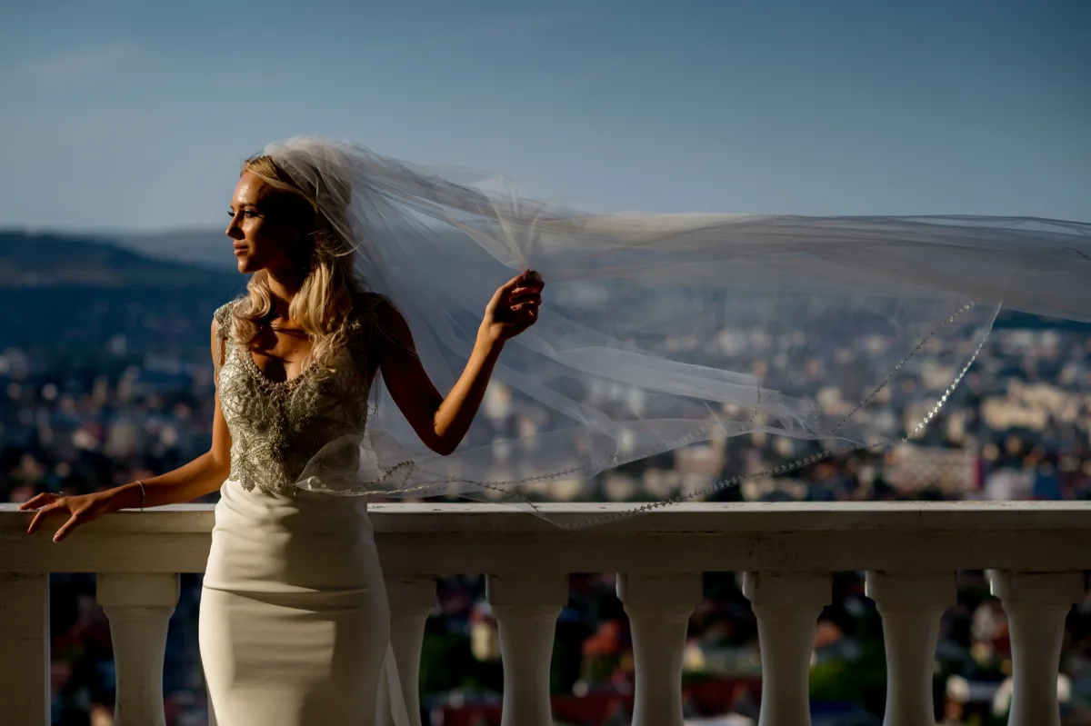 Mireasă pe balconul camerei de pregătiri de la Grand Hotel Italia, cu Clujul în spate