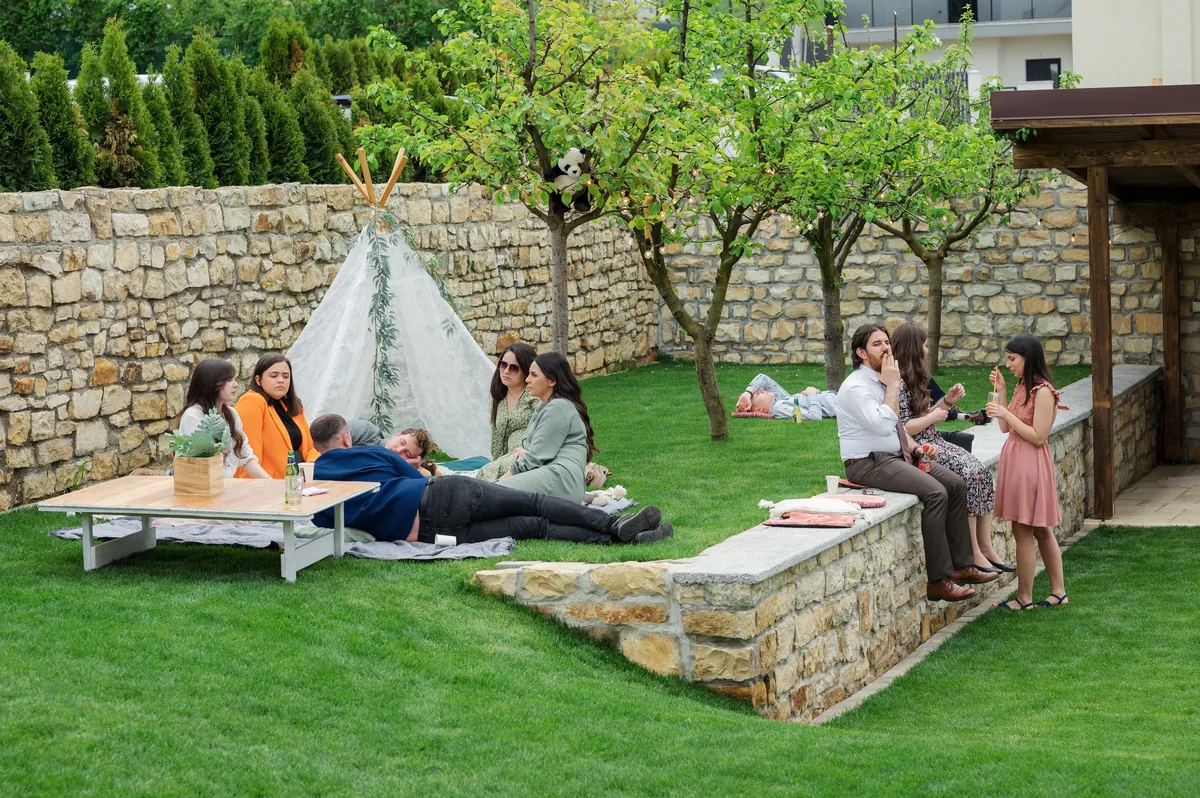 Cadru wide la La Moșu — invitați relaxați pe gazon, cort tip teepee și zid de piatră, botez în aer liber lângă Cluj-Napoca