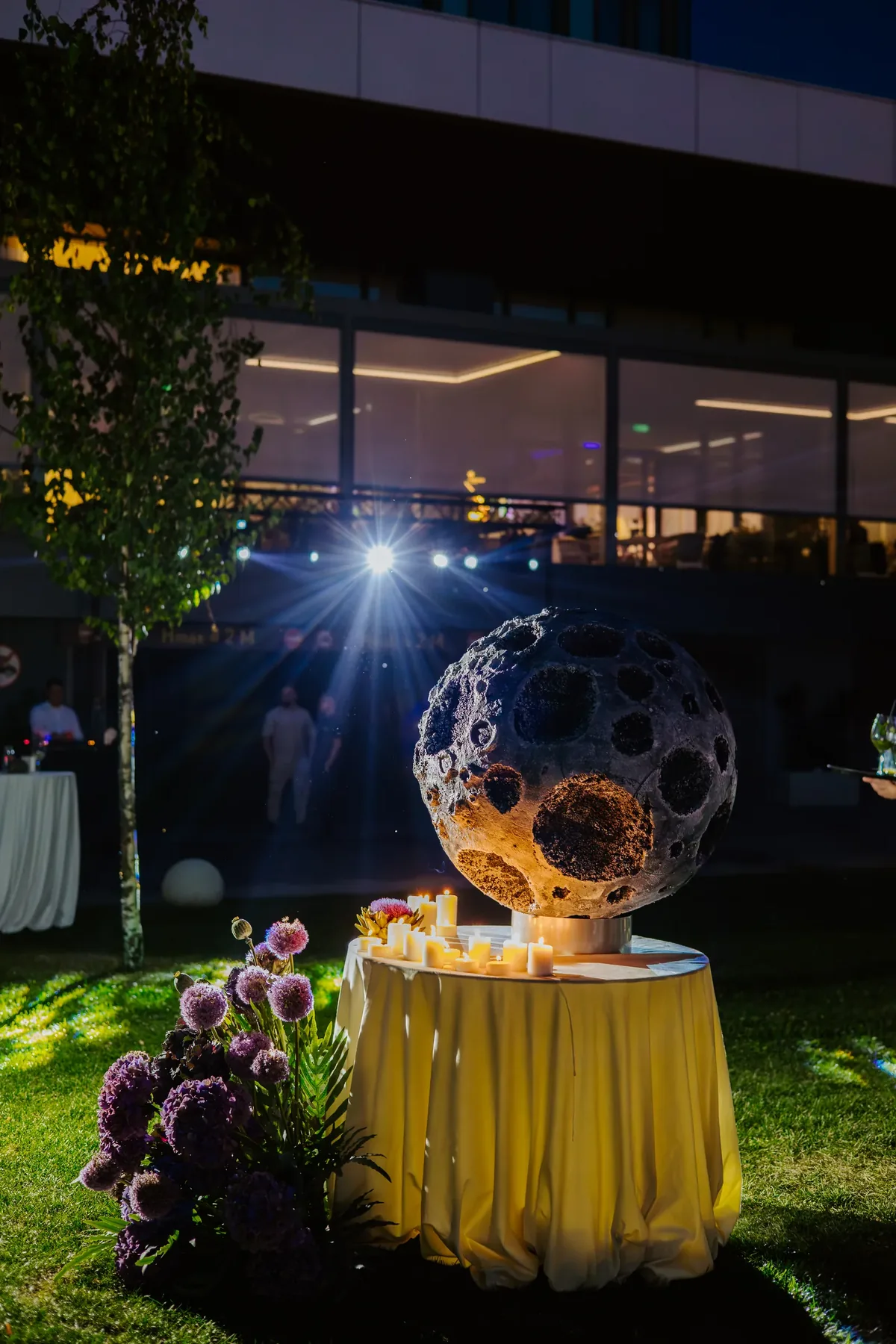 Instalație decorativă în formă de lună, luminată noaptea, în curtea Radisson Blu Cluj-Napoca — detaliu de la un botez tematic