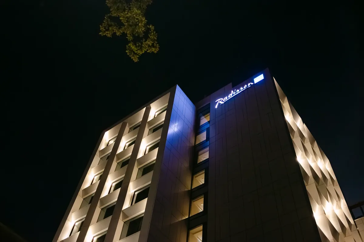 Fațada hotelului Radisson Blu din Cluj-Napoca, seara, cu lumini calde — locație de botez de 5 stele lângă Parcul Central