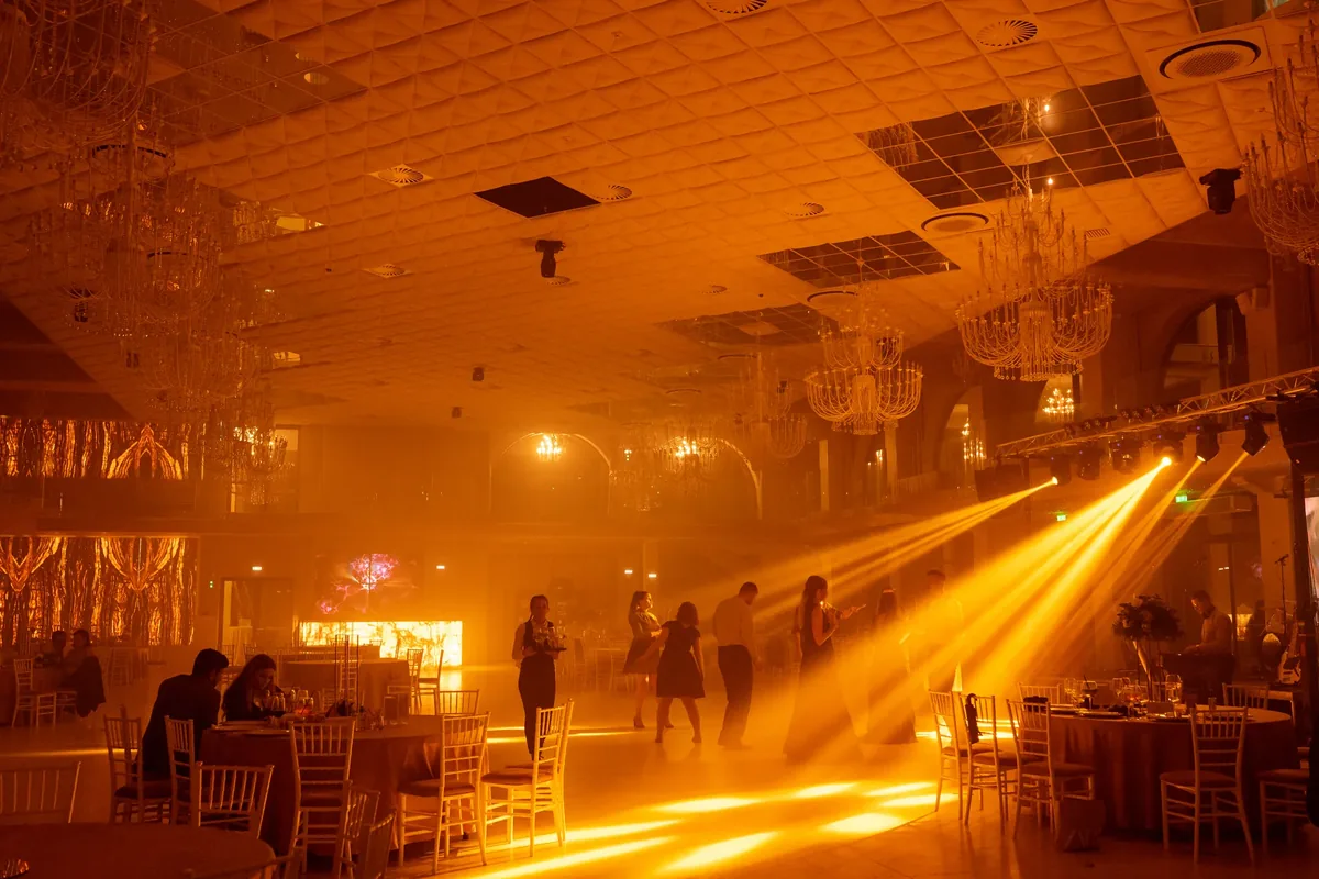 Sala Grande Vista seara, în lumină chihlimbarie, cu fascicule prin fum