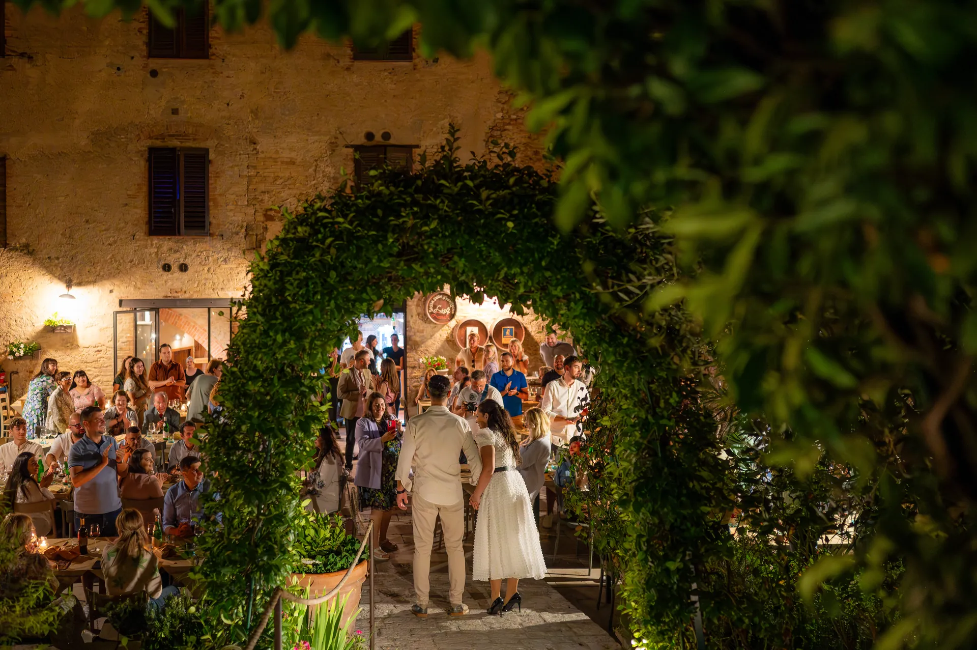Roxana & Ionuț — nunta toscana italia roxana ionut cuplu arcada iederă invitati aplauze — fotograf nuntă